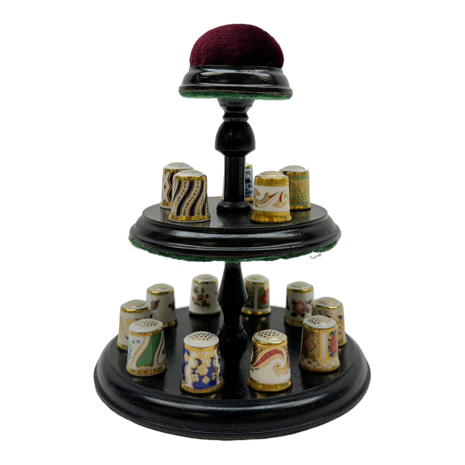 Collection of fifteen Royal Crown Derby thimbles upon an ebonised display stand, together with Royal Crown Derby candle snuffer in Imari pattern 1128