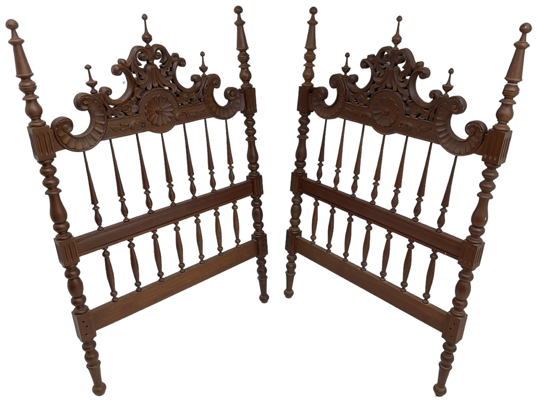 Pair of Spanish carved hardwood headboards, the pediment carved and pierced with shell C-scrolls and carved foliage, turned spindle back, on turned supports 