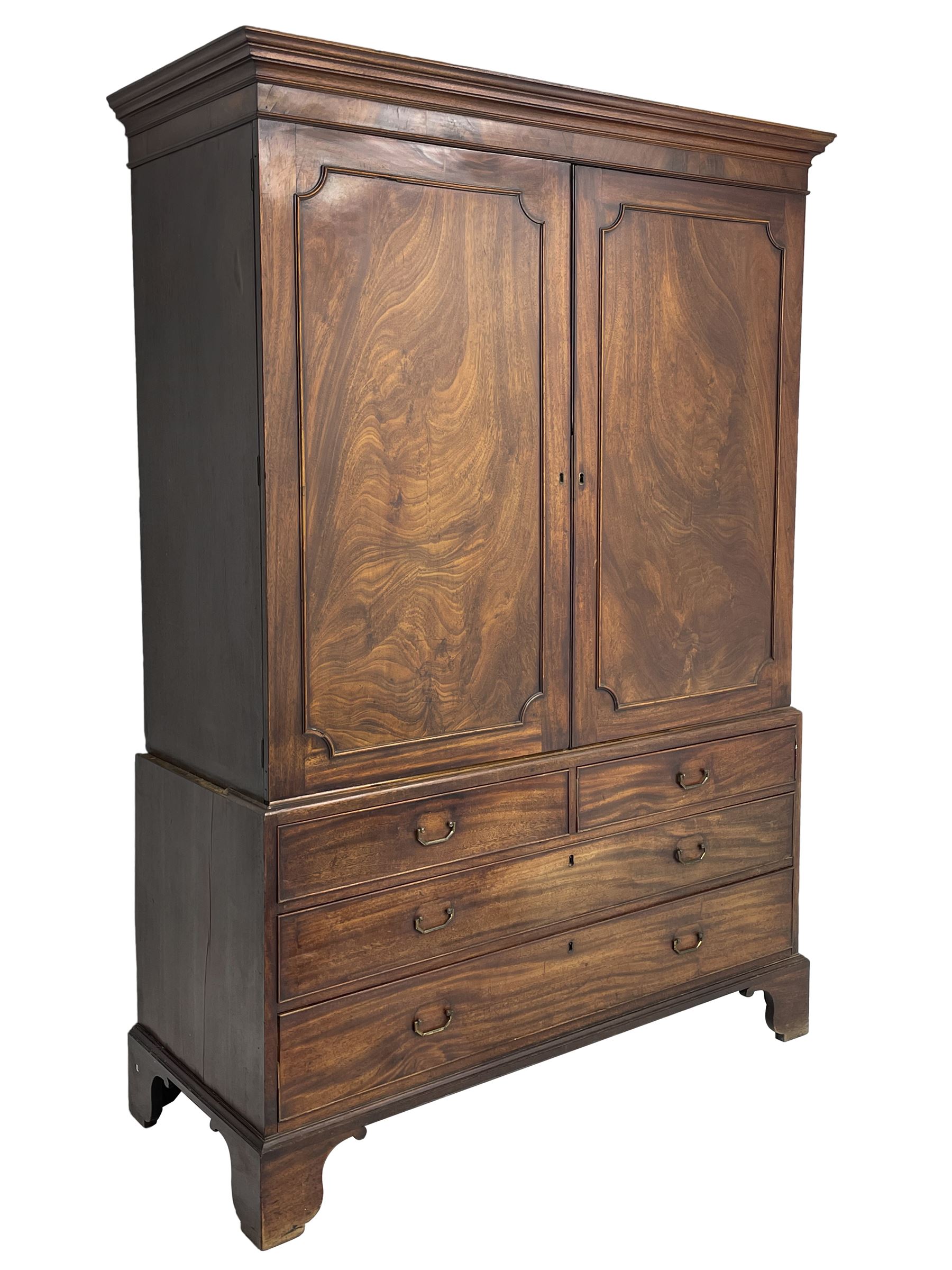George III mahogany linen press, projecting cornice over two figured doors enclosing five linen slides, the lower section fitted with two short and two long drawers, on bracket feet