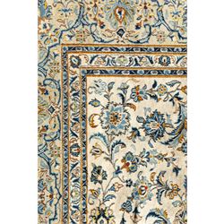 Central Persian Kashan hand-knotted carpet, ivory field profusely decorated with an all-over scrolling vine, palmette, and lotus design in shades of soft blue, pale gold, and green within floral borders