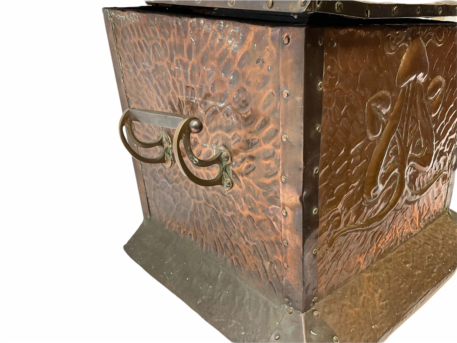 Arts and Crafts copper coal box, of square form with twin curved handles, with hammered finish, and embossed stylised motif to the front and hinged cover, H37cm L40cm D35.5cm