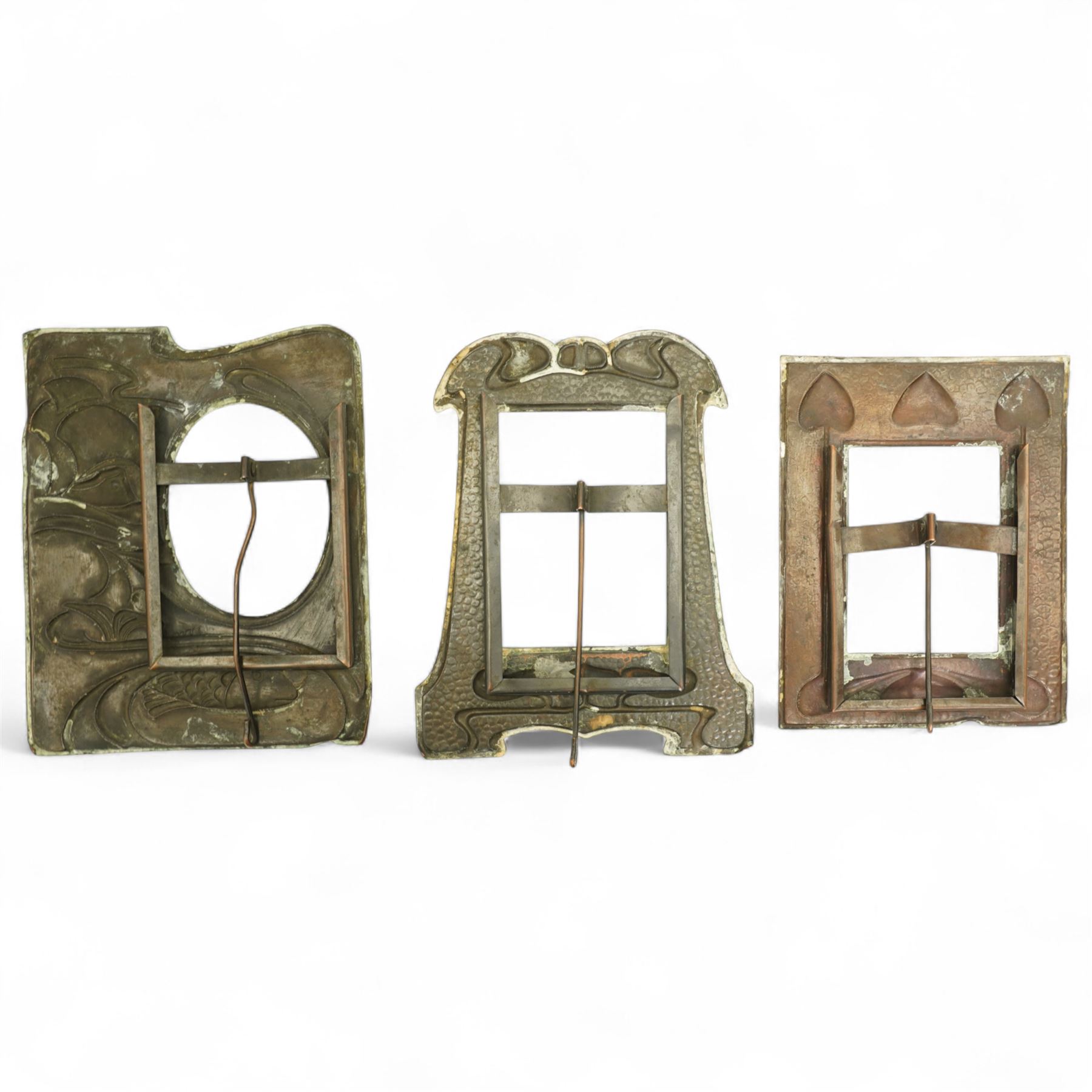 Newlyn type Arts and Crafts copper photograph frame decorated with a fish and galleon 24cm x 20cm with oval aperture and two other Newlyn style beaten copper frames (3)