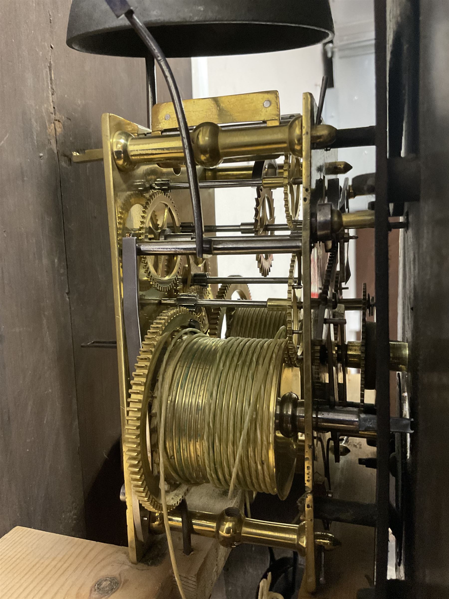 George Clapham of Brigg - Late 18th century 8-day oak cased longcase clock c1790 - flat topped hood with later carved addition, dog tooth moulding and blind fretwork beneath, break arch hood door flanked by reeded pilasters and capitals, trunk with canted corners and  door with a triple arched top, plinth with a later base with decoratively shaped feet, early painted dial with flowers enclosed in a gesso border to the spandrels, rolling moon to the arch, seconds dial and calendar aperture, Roman numerals and five minute Arabic's with makers name (indistinct), dial pinned via a false plate to a rack striking movement. With weights, key and pendulum.