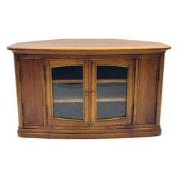 Contemporary cherry wood corner TV unit, canted top over central glazed double doors opening to shelves for media storage, flanked by side storage compartments, on a plinth base