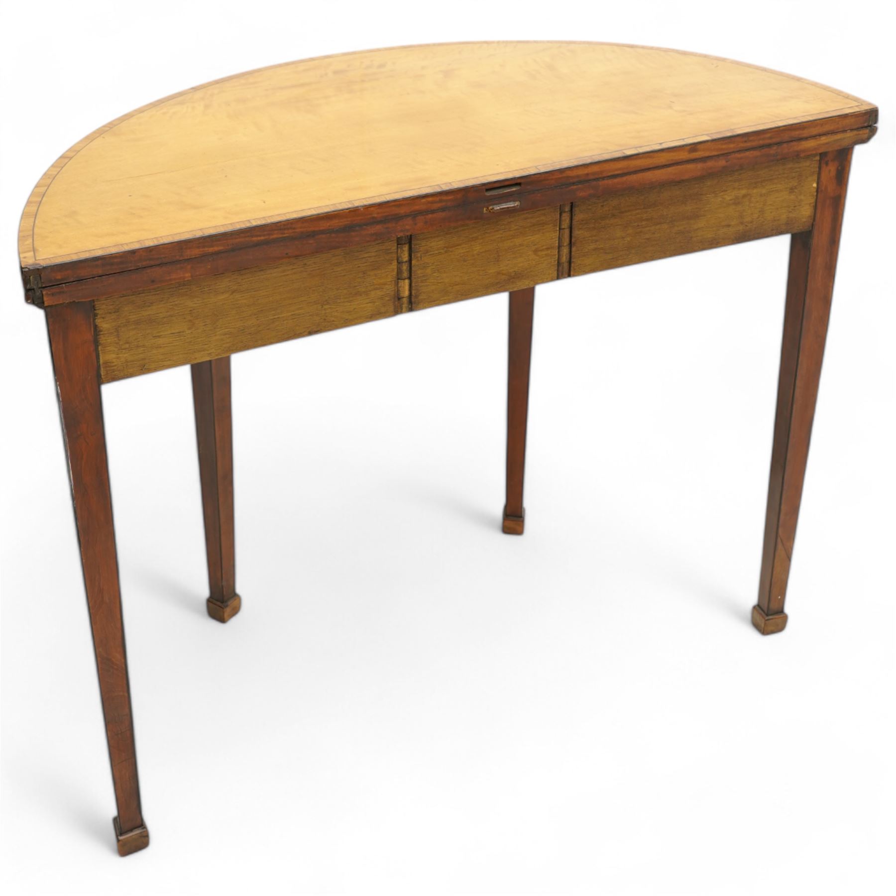 George III satinwood demi-lune tea table, fold-over top over double-gate leg action base, the central frieze rails and support headers inlaid with floral marquetry panels, on square tapering supports and block feet 