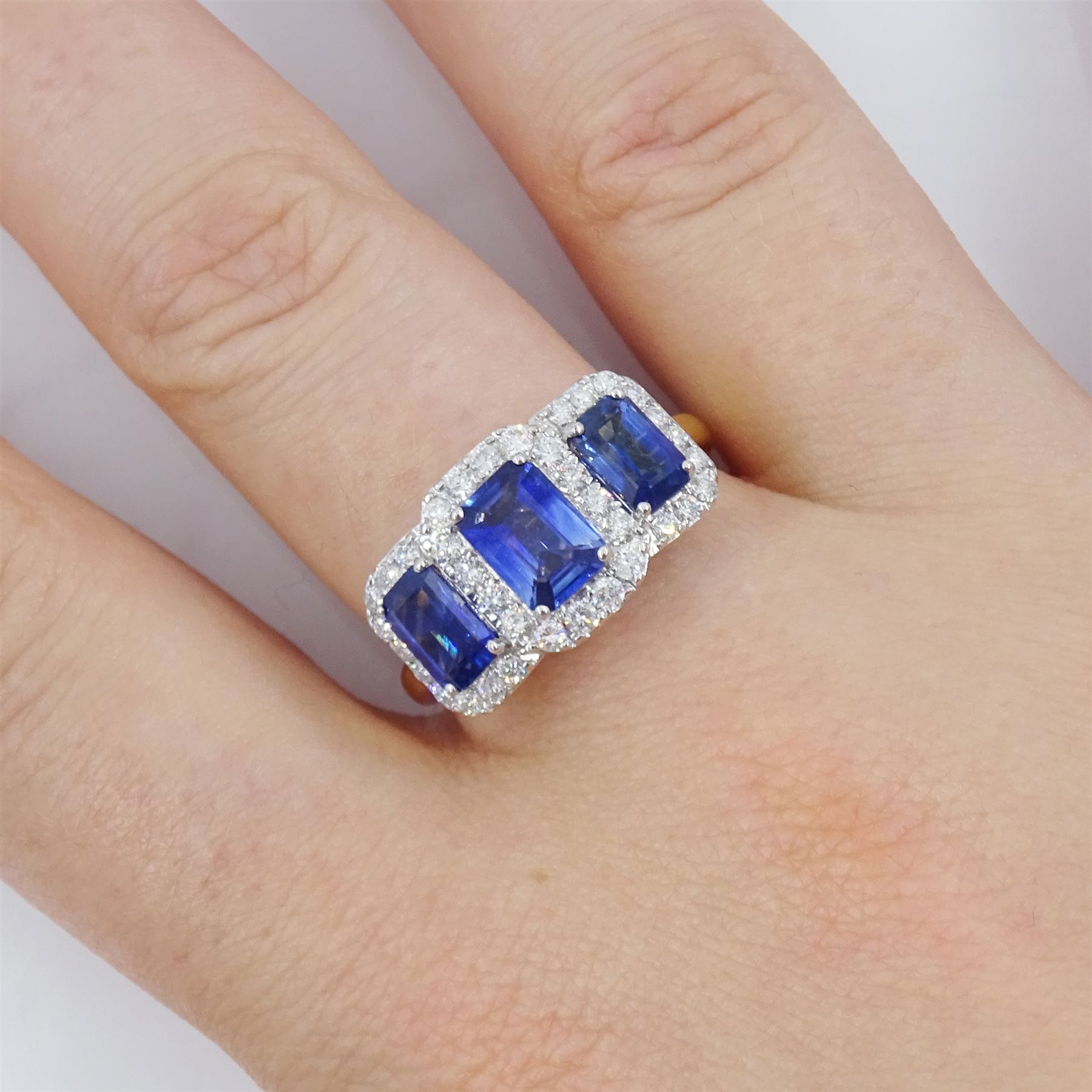 18ct gold sapphire and diamond cluster ring, three emerald cut sapphires, with round brilliant cut diamond surround, hallmarked, total sapphire weight approx 2.25 carat, total diamond weight approx 0.50 carat