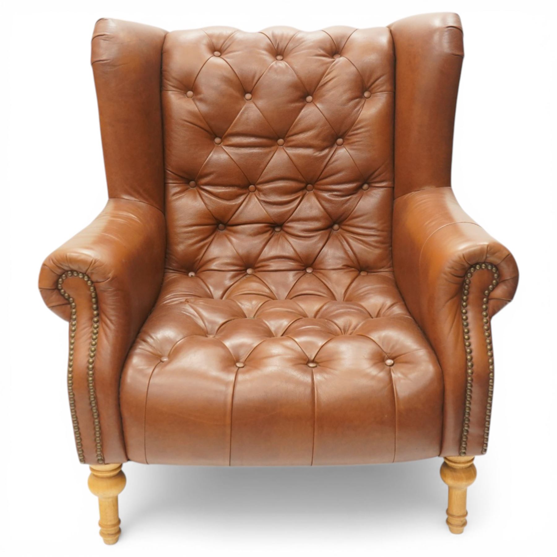 Alexander James design fully tan leather chair, with full button back seat and back, with scrolled arms with studded trim, raised on light stained turned supports