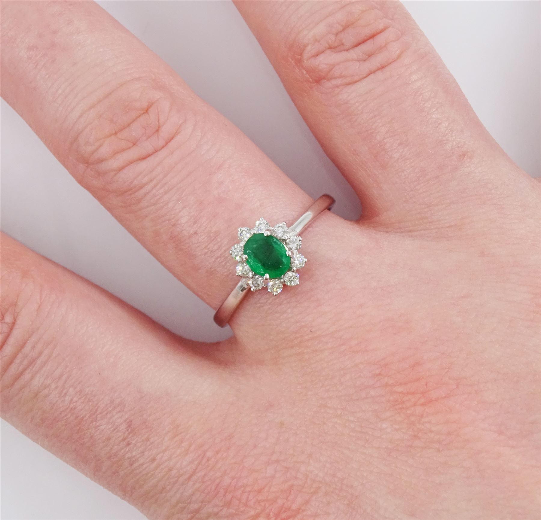 18ct white gold oval cut emerald and round brilliant cut diamond cluster ring, stamped 750