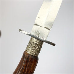 Bowie knife, the 12cm steel single edged saw-back blade marked to the ricasso George Wostenholm Sheffield, brass crosspiece and antler grip; together with a fighting knife with 14.5cm steel double edged blade marked to the ricasso Lockwood Brothers Sheffield, steel crosspiece and antler grip with embossed ferrule, in leather sheath L28cm overall (2)