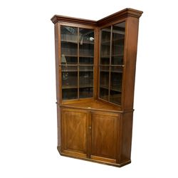19th century mahogany corner bookcase cupboard, projecting cornice over two astragal glazed doors enclosing eight shelves, lower section with two panelled cupboard doors concealing single shelf