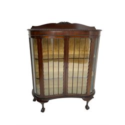 Early 20th century mahogany serpentine display cabinet, raised back carved with foliate scrolls, enclosed by two glazed doors, on ball and claw cabriole feet