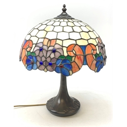 A Tiffany style table lamp, with cast spreading base detailed with tendrils, and leaded glass shade, overall H50cm.