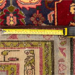 North West Persian Tariz hand-knotted runner, madder red field with a column of linked lozenge medallions in shades of indigo blue and pistachio green framed by stylized floral motifs within triple borders of rosettes and scrolling vines on an ivory ground, with cotton fringe ends