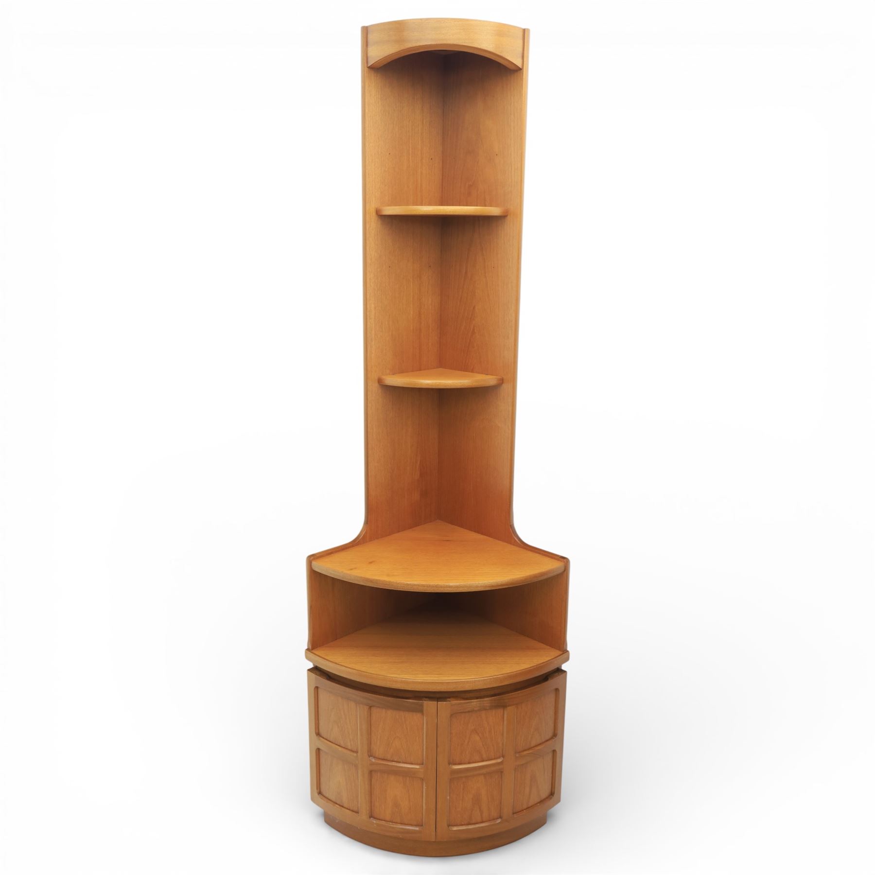 Nathan - teak corner cabinet, the upper section with moulded cornice and two fixed shaped open shelves, above a curved corner cupboard with twin signature square panelled doors, on a shaped plinth