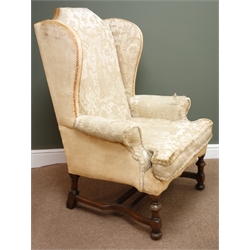  William & Mary style upholstered wing back arm chair, on turned walnut supports joined by double stretchers, H118cm, W84cm, D78cm  