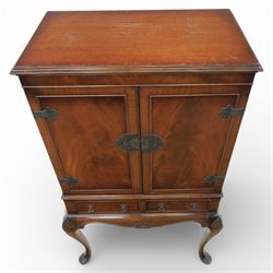 20th century Queen Anne style mahogany cocktail cabinet, moulded cornice above a pair of fielded panel doors with decorative strap hinges and central escutcheon, opening to a mirrored interior fitted with tiered shelves with brass gallery rails, pull-out glass inset mixing slide above three short drawers, shaped apron on cabriole supports with carved shell knees terminating in pad feet