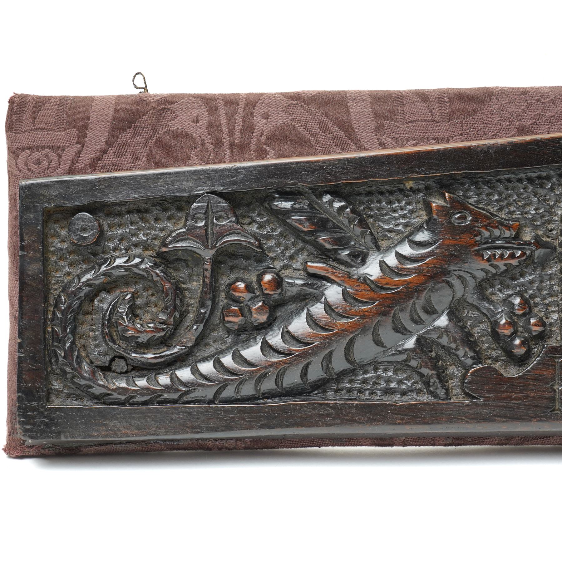 17th century walnut frieze, or pediment, carved with a smiling mans faced flanked my two creatures, incised date 1617, mounted on fabric panel, W52cm