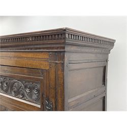 Large 18th century and later oak livery cupboard, the projecting dentil cornice over panelled front and two panelled doors, carved with scrolls and lozenges, the interior fitted with wooden hooks and showing signs of historic paint, panelled sides and boarded back, on shaped apron and bracket feet