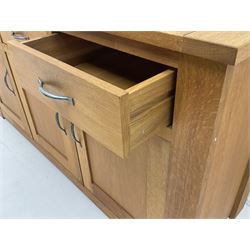 Light oak sideboard, three drawers above three cupboards enclosing shelving, stile supports