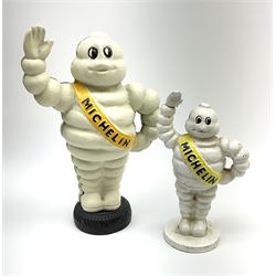 A cast iron Michelin man type money box, H23.5cm, together with a similar smaller example, H17cm. 