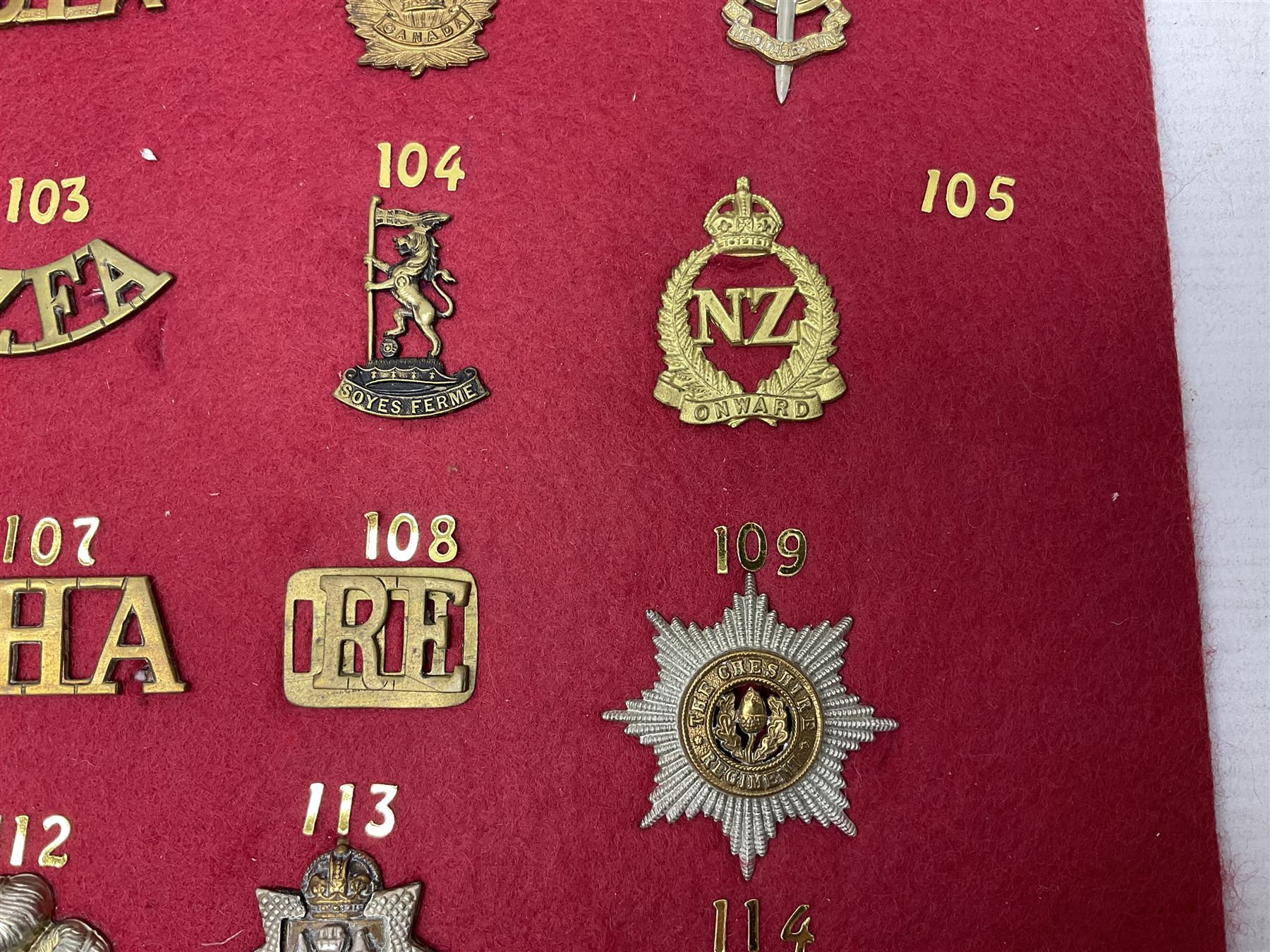 Forty glengarry and cap badges and shoulder titles including Gordon Highlanders, Canada and Canadian Field Artillery, New Zealand Field Artillery and Rifle Regiment, Shropshire Light Infantry, 14th/20th Kings Hussars, 17th Lancers, Northamptonshire Yeomanry, Royal Lincolnshire, Special Air Service, 19th Alexandra P.W.O. Hussars etc; mounted on two boards for display (2)