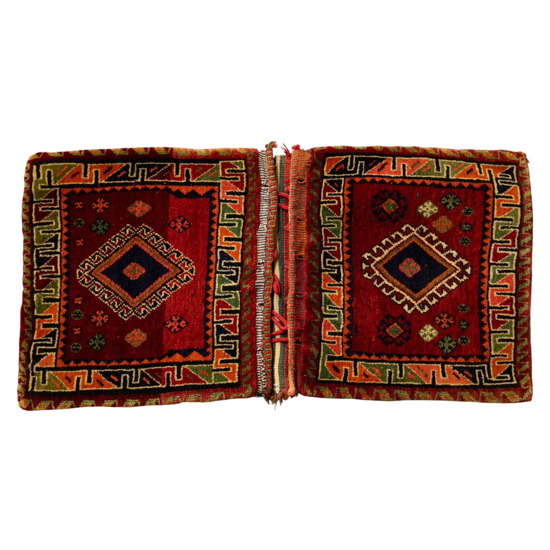 South West Persian Qashgai saddlebag, (Khorjin), woven in geometric designs with central lozenge medallions on a rich madder red ground, decorated with tribal motifs in indigo, ivory green, and ochre, the reverse  with panels of stripped flatwoven kilim 