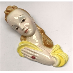A 20th century American Goldscheider Art Deco wall mask, modelled as a blonde haired female in yellow dress, with printed marks to interior, Goldscheider Everlast, H36cm. 