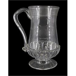 Early 19th century glass tankard, with part fluted base and ribbed band to rim, upon a spreading circular foot enclosing a silver George IV shilling, H19.5cm