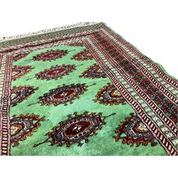 Persian Bokhara jade ground rug, the field decorated with Gul motifs, within a geometric multi-band border with lozenge patterned ends