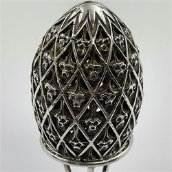 Modern silver limited edition Easter egg, no. 70/500, the openwork lattice body decorated with gilded panels of flower heads, opening to reveal a gilt interior, upon silver stand with three scrolling pad feet, each hallmarked St James House Company, London 1979, height including stand 8cm