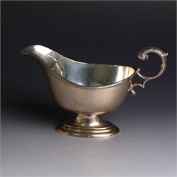 1930s silver sauce boat, of typical form with acanthus capped flying C scroll handle and upon stepped oval foot, hallmarked William Hutton & Sons Ltd, Sheffield 1938, height including handle H10cm