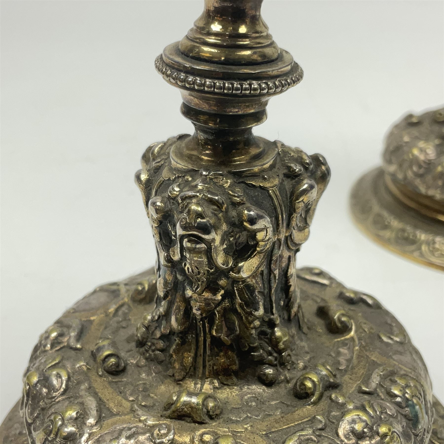 Pair of Victorian Elkington Mason & Co silver plated candlesticks, decorated in relief with ram masks and figures, H14cm