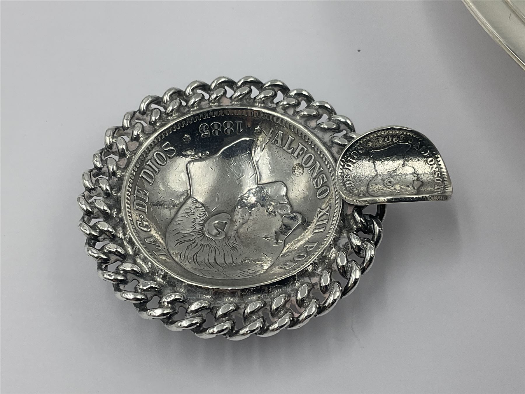Spanish silver coin dish, with white metal chain rim and upon three ball feet, together with a silver plated armada style dish, with cast racehorse and jockey to centre, coin dish D4.8cm, armada dish D20.5cm