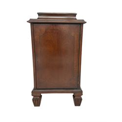 Regency style mahogany pedestal cabinet, sarcophagus top over single door enclosing drawer, the sides inlaid with star motifs, on square tapering lobe carved feet