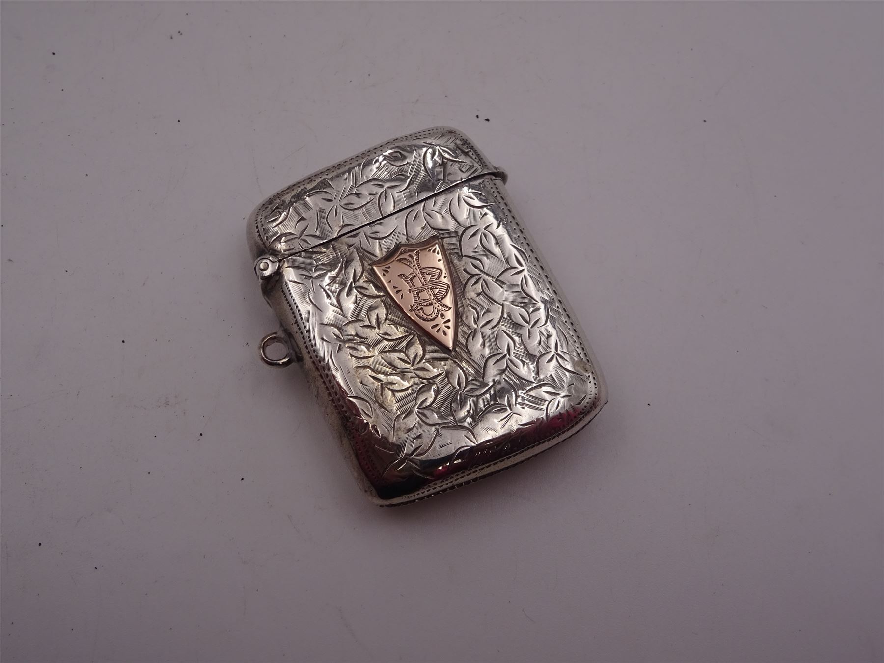 Group of silver, comprising 1930s pepper, of typical plain form, hallmarked Harrods Ltd, London 1938, together with an Edwardian vesta case, with engraved foliate decoration and monogramed rose gold shield cartouche, hallmarked G Loveridge & Co, Birmingham 1901, a pair of Victorian apostle top spoons, with pierced figural twisted stems, hallmarked Martin, Hall & Co, Sheffield 1864 and a modern silver candle snuffer with turned wooden handle, hallmarked R&D, Sheffield 2004