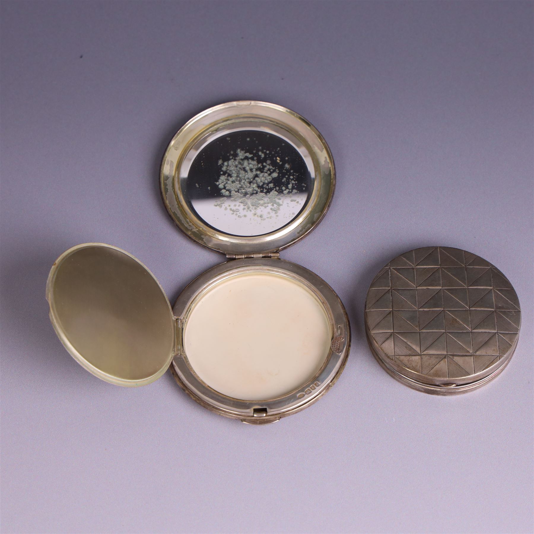 Two silver circular compacts, including Continental 800 silver example with geometric decoration, stamped 800 and a Kigu example with engine turned concentric circle decoration, hallmarked Kigu Ltd, London 1963, largest D7.5cm