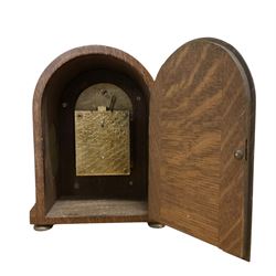 German- early 20th century oak cased 8-day mantle clock, with a round top, side frets and conforming glazed door to the dial, single sheet silvered dial with a silvered chapter and fast/slow regulation dial, Roman numerals, minute track and spade hands, going barrel movement with a lever platform escapement. With Key. 