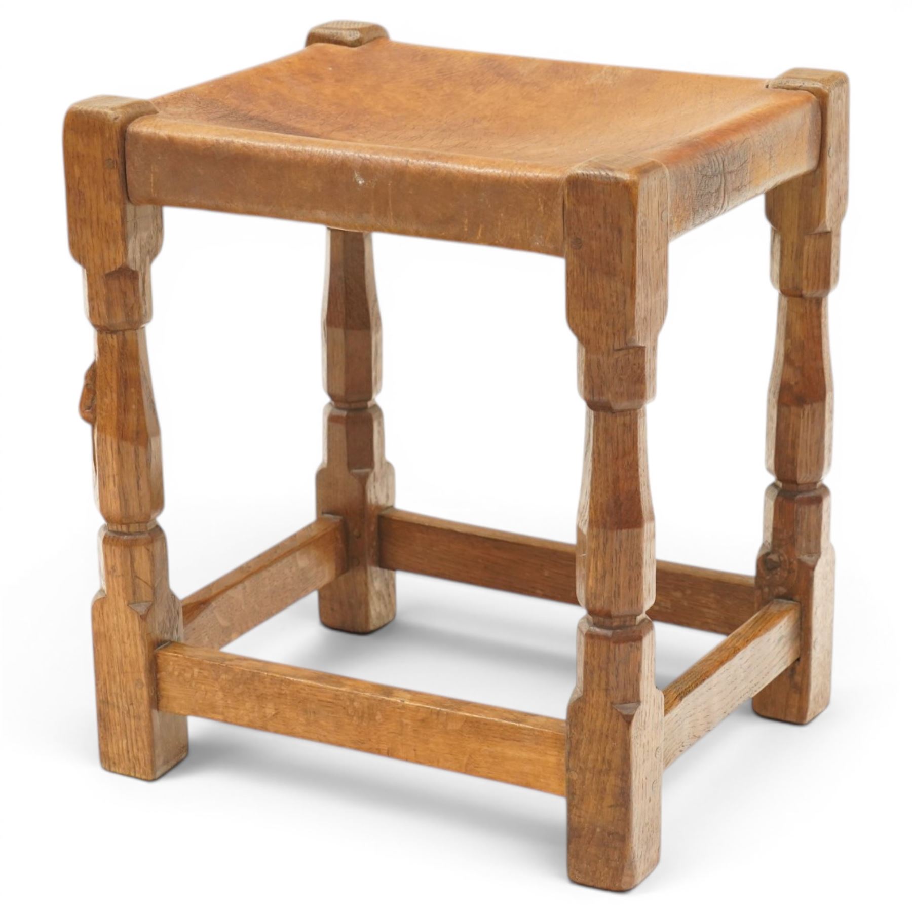 Mouseman - 1950s dark oak dressing table stool, the rectangular top with tan leather seat, raised on octagonal supports united by box stretcher, carved with mouse signature, by the workshop of Robert Thompson of Kilburn