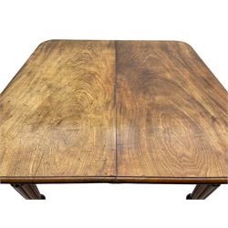 Early 19th century figured mahogany extending dining table, the rectangular top with moulded edge and rounded corners, pull-out action with three additional leaves, raised on turned and lobe carved supports with brass cup castors