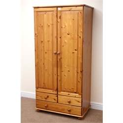  Solid pine double wardrobe, two doors enclosing hanging rail above two short and one long drawer, bun feet, W87cm, H176cm, D52cm  