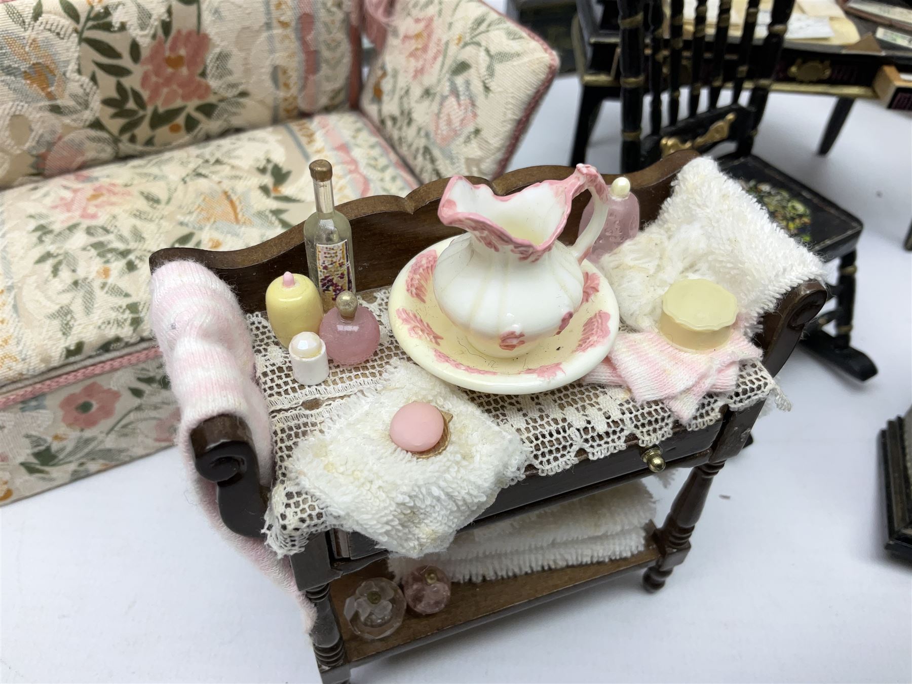 Collection of miniature dolls house furniture, to include five drawer chest painted with blossom, cream and gilt double door mirrored wardrobe, four piece lacquered style desk set, three piece suite, writing desk, wash stand, Knoll style sofa etc (14)