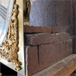 Henry De La Feuille of London-early 18th century marquetry 8-day longcase clock c 1720, hood with a moulded upstand to the domed caddy top, set on a lower upstand above a wide cornice with a marquetry frieze beneath, square hood door with marquetry inlay and attached three-quarter columns with wooden capitals, hood sides with glazed panels, trunk and door inlaid with figural marquetry with various representations of people, birds, scrollwork and foliage, full length door with cock-beading surround and a circular glazed lenticle, the case sides veneered with bordered panels within crossbanded surrounds, plinth with a convex moulding and shallow moulded skirt, brass dial with a matted centre and ringed winding holes, date aperture and seconds dial, silvered chapter with Roman numerals, five minute Arabic’s, minute and inner quarter hour tracks and half-our markers, with pierced steel hands and matching cast scroll spandrels depicting angels supporting a crown, dial pinned directly to a four pillar movement with an outside countwheel and recoil anchor escapement, striking the hours on a cast and polished bell.
With weights, pendulum and key.

Henry De La Feuille was a French Huguenot, born in 1670, moving to Jersey c1690 and finally London where he is thought to have died c1730.
