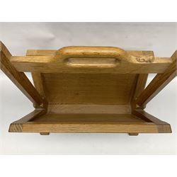 Mouseman - oak magazine rack, the top rail pierced with handle and carved with mouse signature, octagonal supports with two panelled and splayed sides, on sledge feet, by the workshop of Robert Thompson, Kilburn 