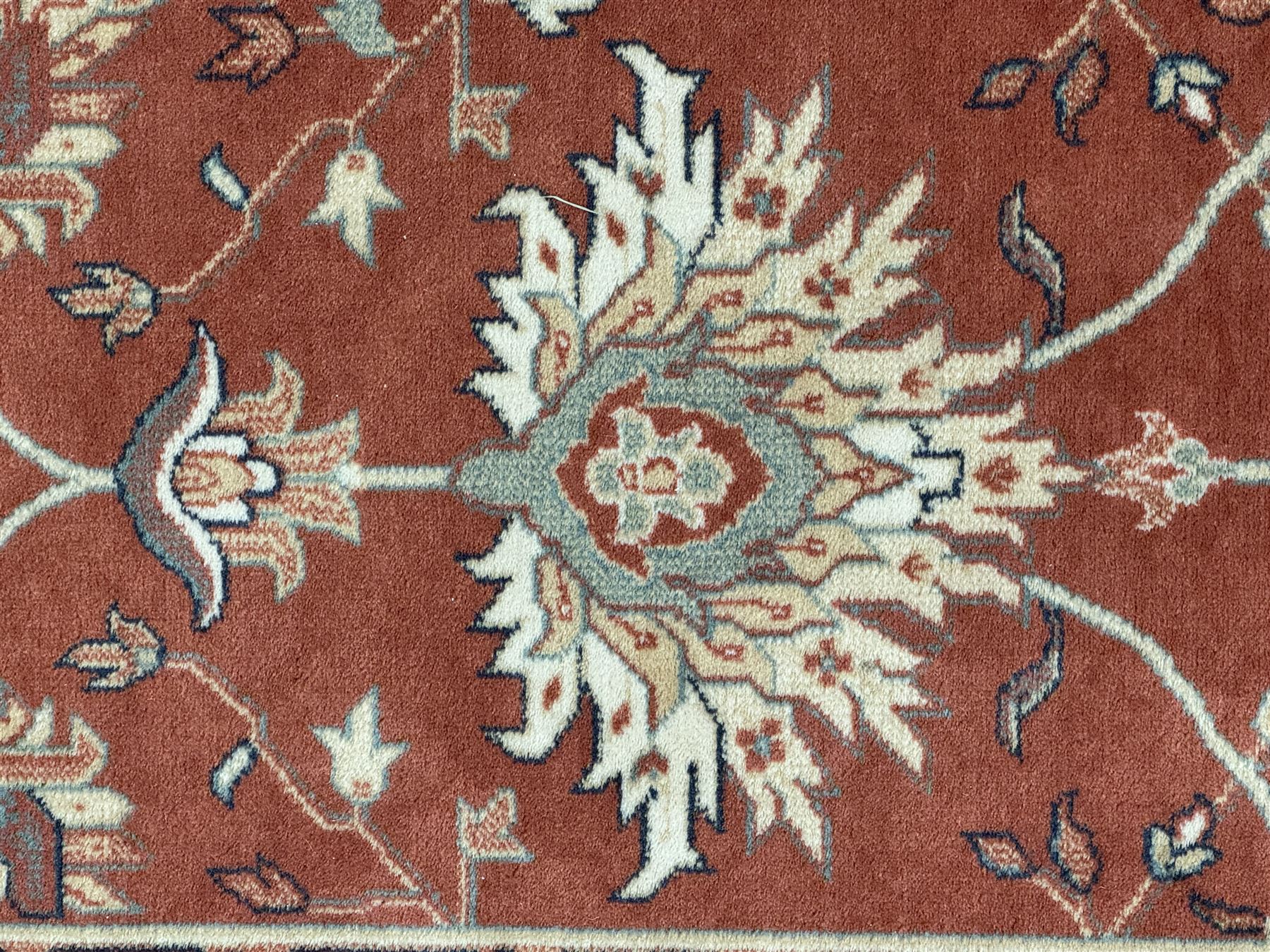 Late 20th century Royal Keshan 'Agra' hand-knotted wool rug, terracotta ground with central floral medallion and scrolling vines, enclosed by a cream border with repeating floral motifs