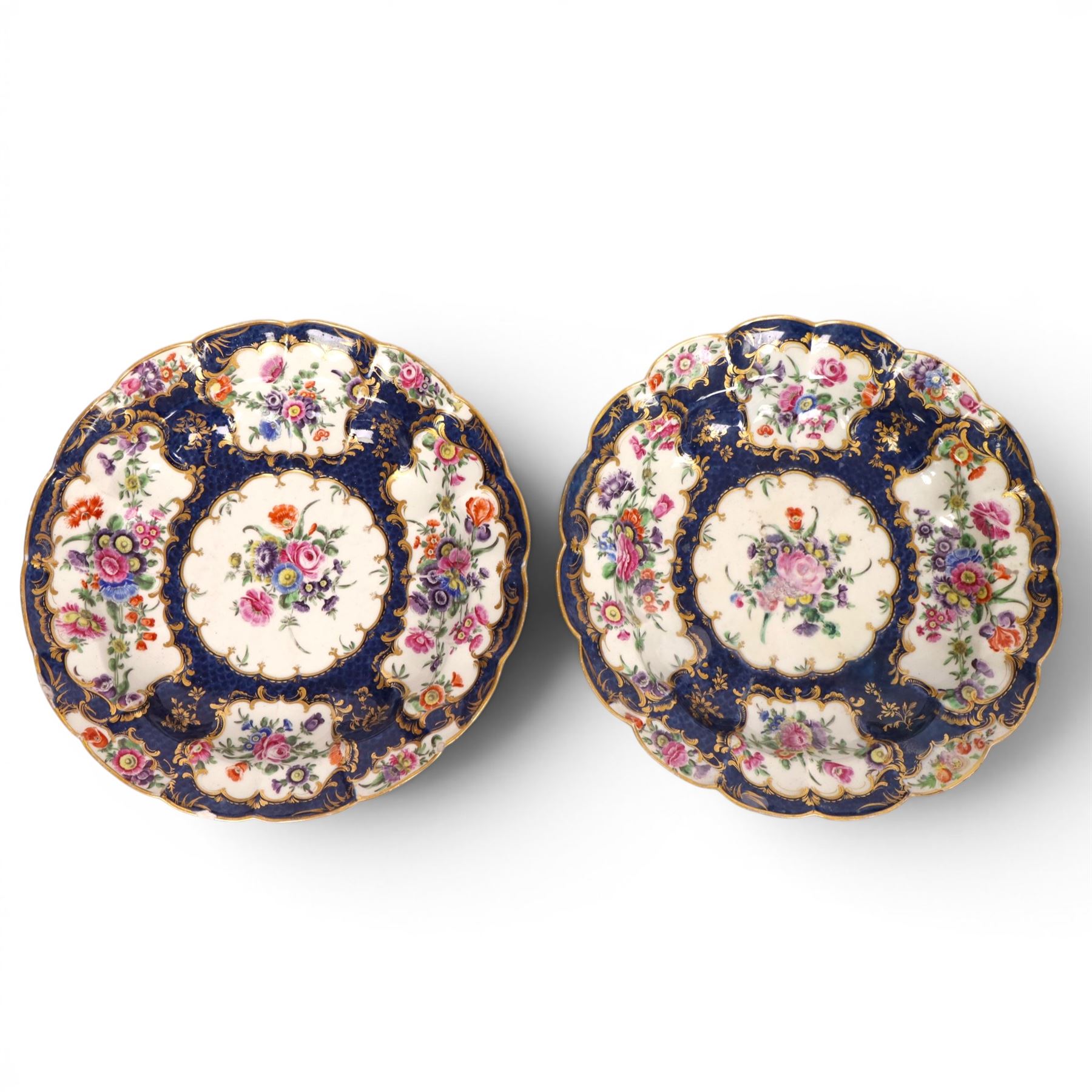 Pair of Worcester junket dishes, c1770, painted with panels of flowers on a blue scale ground within richly gilt rococo style borders and scalloped rim, hatched square mark to base, D24.5cm (2)
Notes: label suggests provenance relating to the Brownlow family of Belton House.