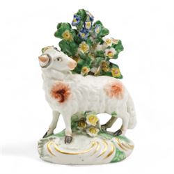 Two 18th century Derby porcelain groups modelled as a ram standing before bocage above a recumbent lamb, upon flower encrusted base, H15cm and two further Derby figures modelled as a ram and cow and calf (3)