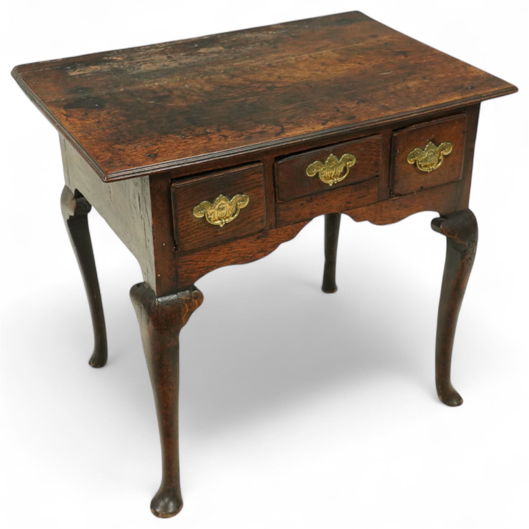 18th century oak lowboy, the three frieze drawers fitted with later brass handles, over shaped apron and cabriole legs with pad feet