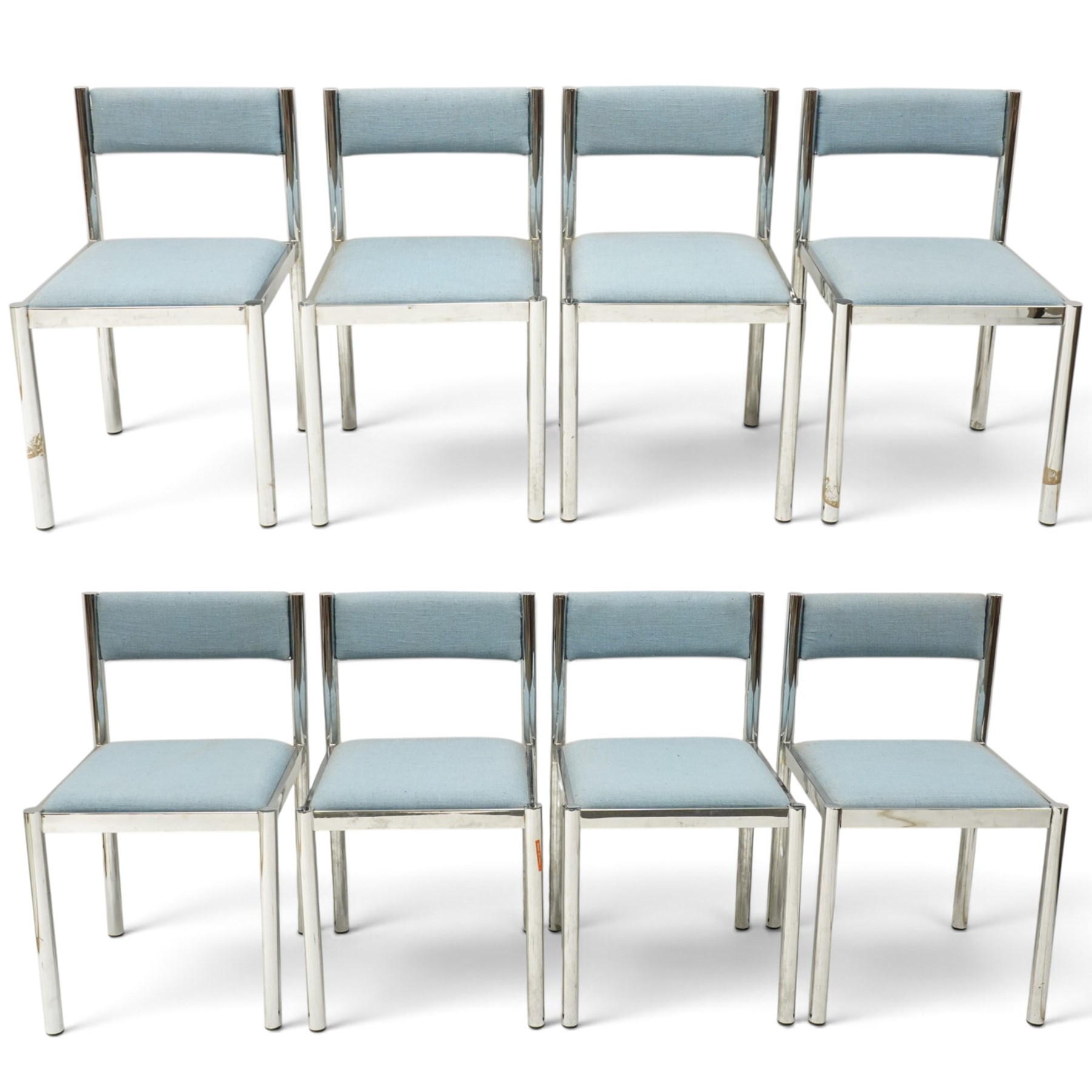 Set of eight 1980s chrome and upholstered dining chairs, curved back bar over padded seats upholstered in blue fabric, on tubular chrome frames