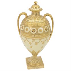 Royal Crown Derby twin handled vase and cover, circa 1886, decorated with raised and tooled gilt borders of foliate scrolls and husk swags upon a cream ground, H38cm