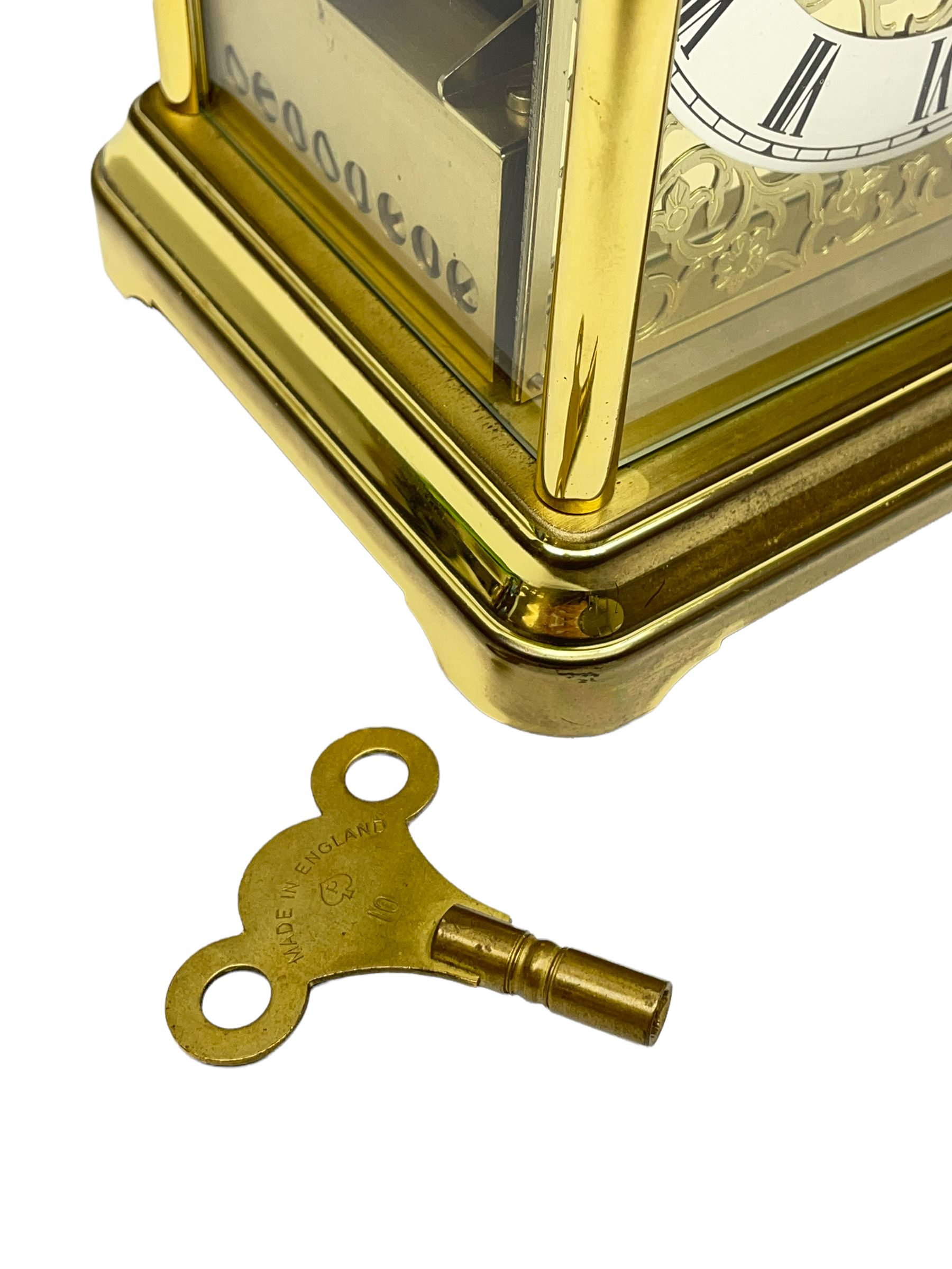 A 20th century brass cased Kieninger (German) chiming mantle clock with a break arch top and three glazed panels, polished sheet brass dial with applied  brass fretwork and a silvered chapter ring, Roman numerals, minute track, steel serpentine hands and seconds dial, three-train spring driven 8-day movement with Westminster, St Michael and Whittington chimes on 8 gong rods, 9 jewel lever platform escapement.  With key. 